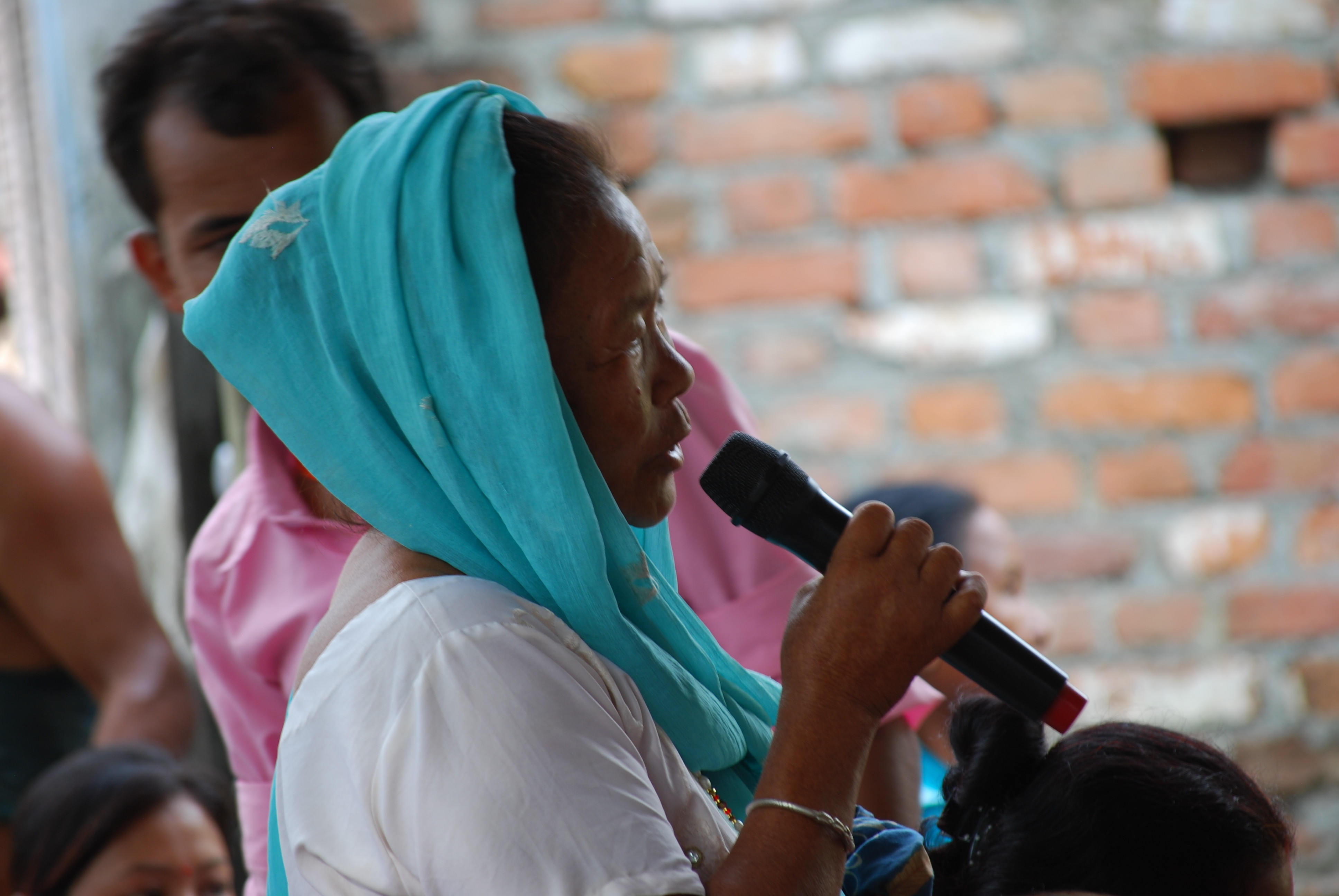 Woman with headscarf member speaking at a local forum.