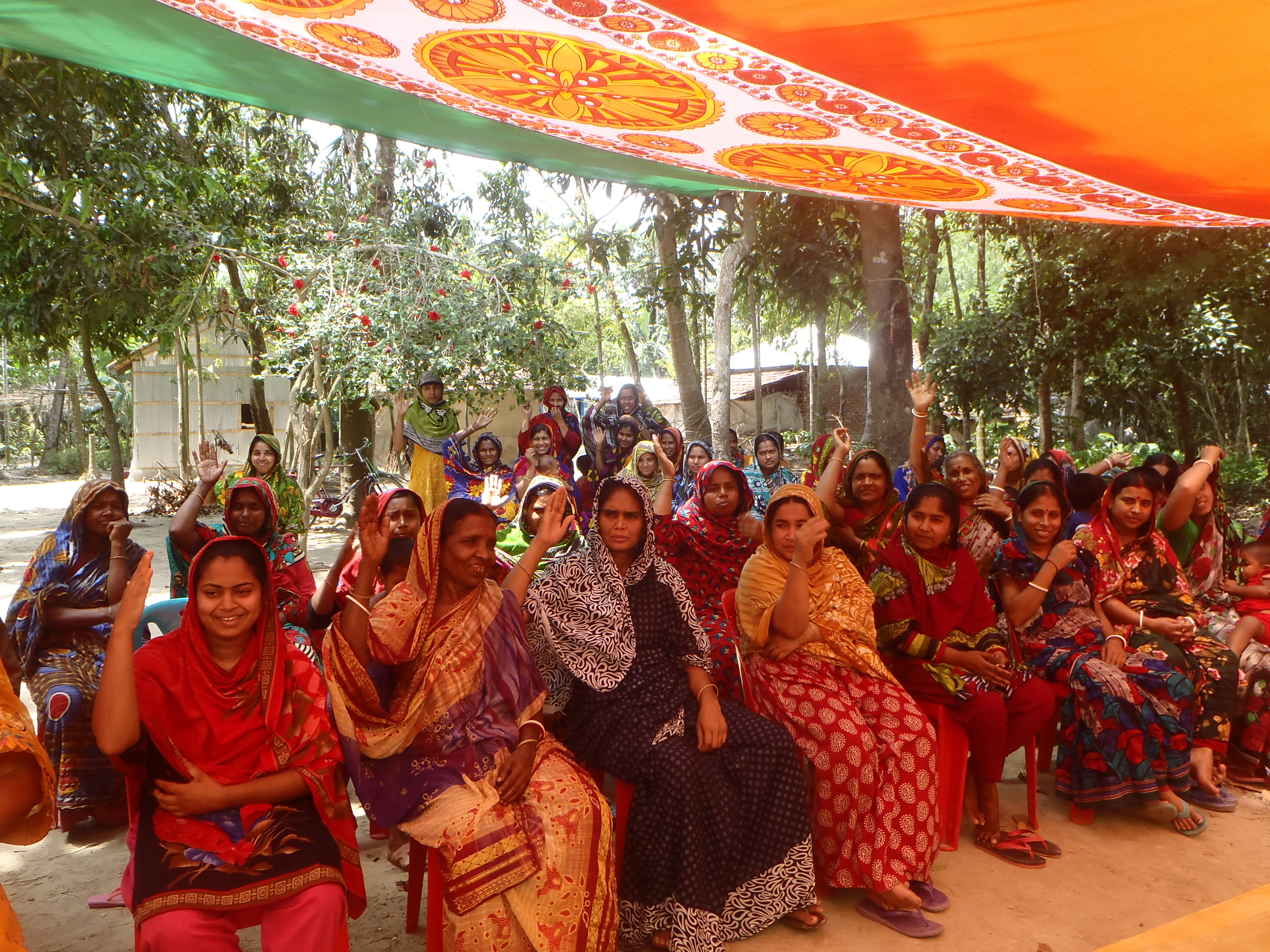 Group of women raising their hands and smiling.